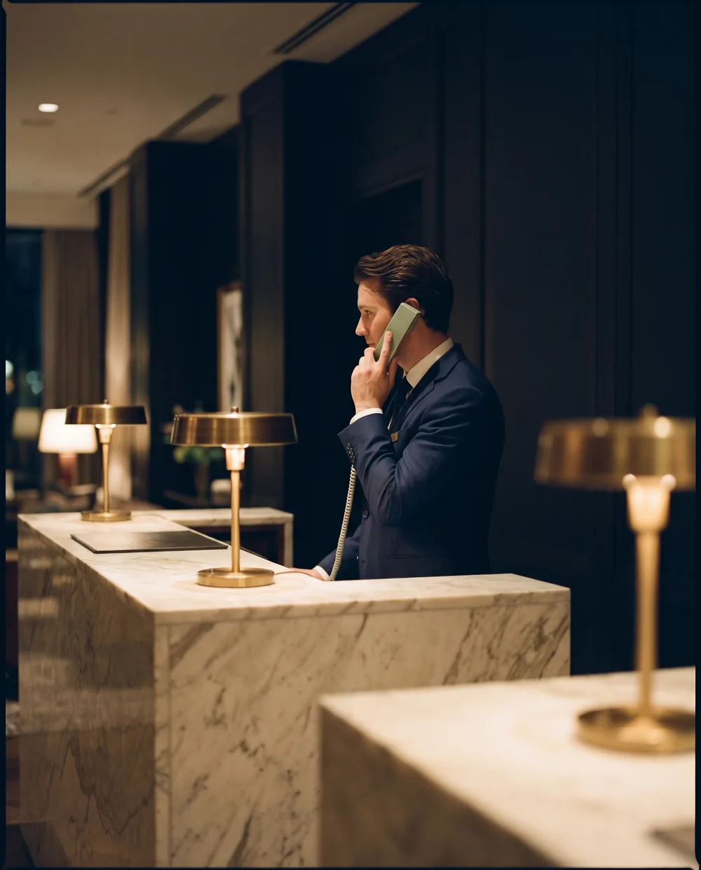 A concierge on the phone at a marble desk